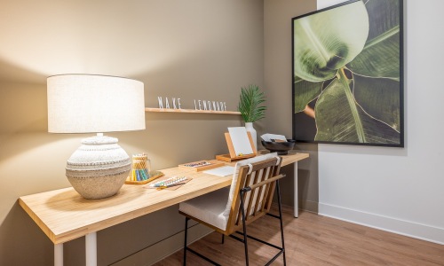 a room with a desk, chair and a lamp